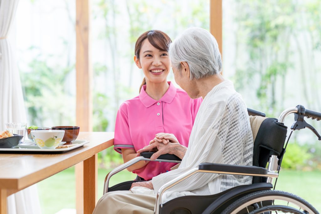 傾眠傾向の高齢者が介護士に話しかけられている